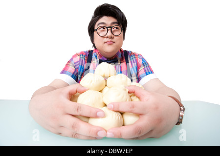 Overweight young man with steamed stuffed buns Stock Photo