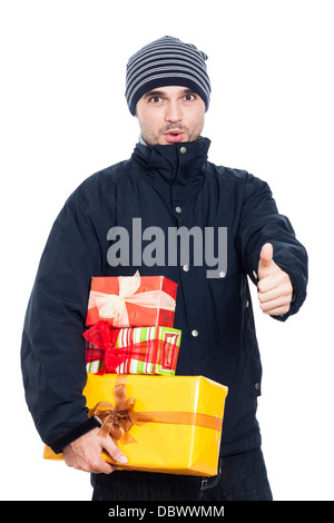 Surprised man with presents showing thumb up, isolated on white background. Stock Photo