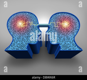 Teamwork solutions business concept with a group of three dimensional human head shaped maze or labyrinth puzzles with a connected glowing line of communication between the partners as a symbol of team success. Stock Photo