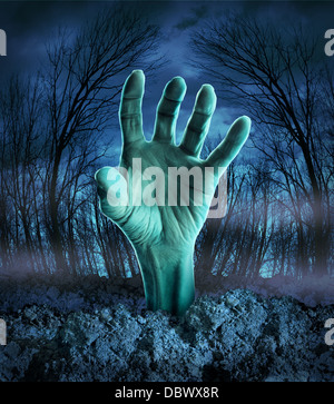Zombie hand rising out of the ground in a spooky dark forest with creepy trees and fog as a symbol of Halloween imagination with a dangerous monster coming back from the dead. Stock Photo