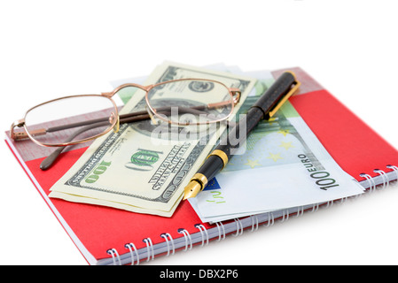 The pen, spectacles, dollars, euro are lying on a red notebook Stock Photo