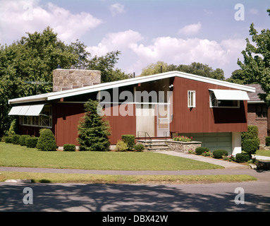 1950s 1960s RED SPLIT LEVEL STYLE HOUSE WITH A STONE CHIMNEY TYPICAL MID-CENTURY MODERN Stock Photo