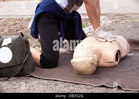 paramedic demonstrates CPR on dummy Stock Photo