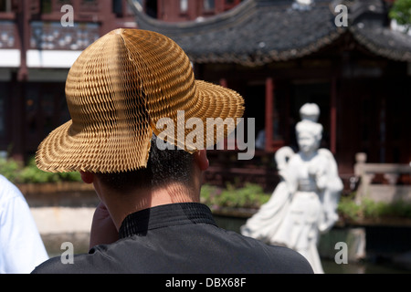 Paper sun hat on a Chinese male visitor to Huxinting (heart-of-lake), 'The Willow Pattern Tea House', Shanghai, China. Stock Photo