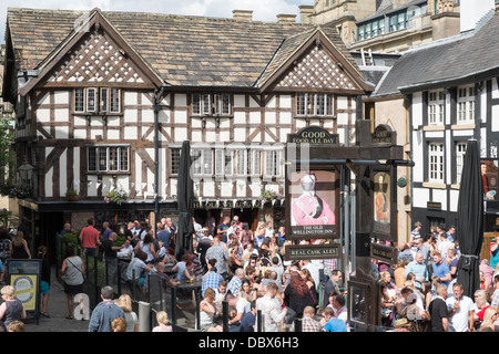 Crowds of people drinking outside 16th century timbered The Old Wellington Inn 1552 in summer in old Shambles Square Manchester England UK Britain Stock Photo