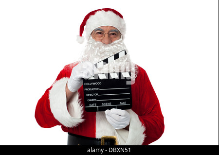 Cheerful aged Santa posing with a clapperboard Stock Photo