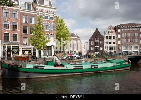 Picturesque city of Amsterdam in Netherlands, North Holland, barge converted houseboat on Prinsnengracht canal.