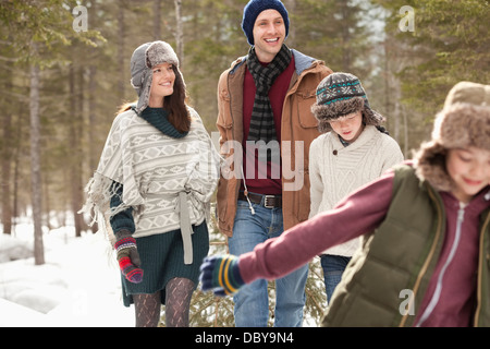 Happy family pulling Christmas tree in snow Stock Photo