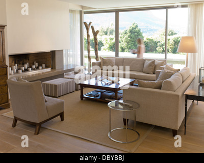 Woman walking at window of living room Stock Photo