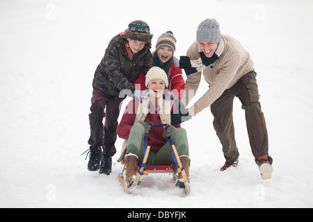 Happy family sledding in snow Stock Photo