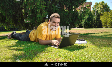 college student lying on the grass in the sun Stock Photo