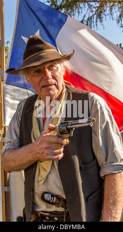 Cowboy with a hand gun, knife in belt on trousers, neckerchief, brown hat Stock Photo