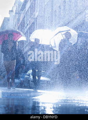 Business people with umbrellas in rain Stock Photo