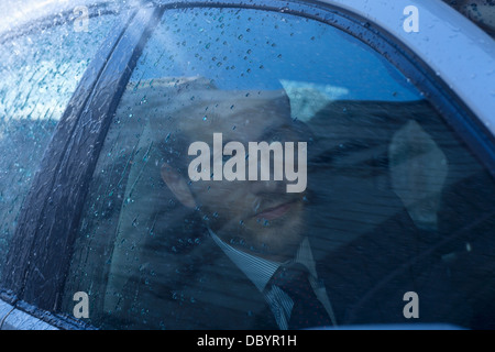 Close up of businessman in car looking up at rain Stock Photo