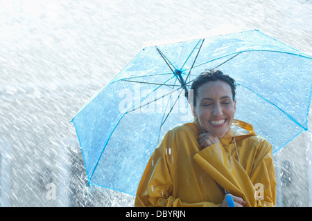 Happy woman under umbrella in rain Stock Photo