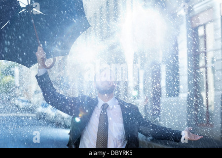 Enthusiastic man with broken umbrella in rain Stock Photo