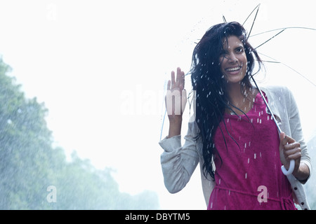 Portrait of smiling woman under umbrella in rain