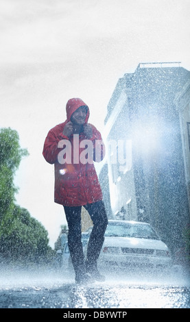 Man in raincoat walking in rainy street Stock Photo
