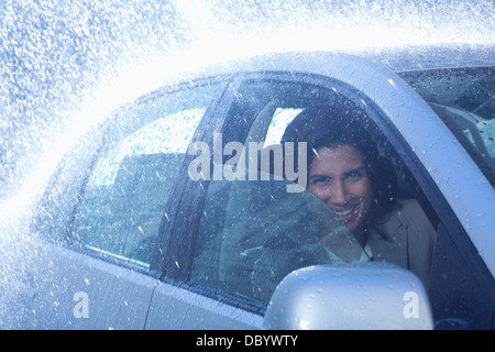 Portrait of smiling businesswoman inside car in rain