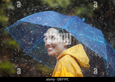 Happy woman with umbrella in rain Stock Photo