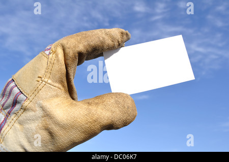Workman's hand in glove holding blank business card Stock Photo