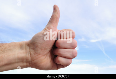 Male hand making thumbs up sign outdoors Stock Photo