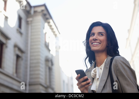 Happy businesswoman text messaging with cell phone Stock Photo
