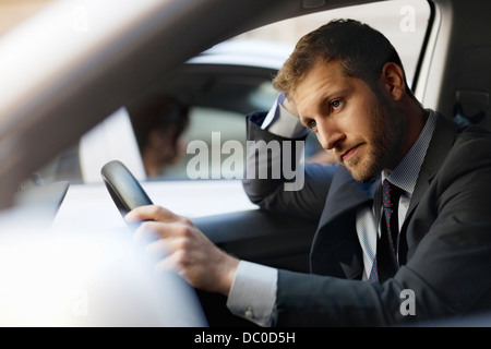 Unhappy businessman stuck in traffic inside car Stock Photo