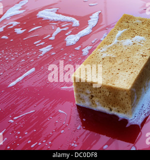 Motor hood being cleaned with sponge and soap Stock Photo