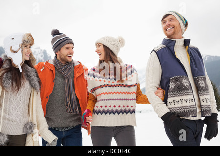 Happy friends walking in snow Stock Photo