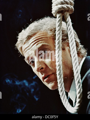 1960s 1965 MICHAEL CAINE AS HARRY PALMER WITH HANGMAN’S NOOSE IN MOTION PICTURE THE IPCRESS FILE LOOKING AT CAMERA Stock Photo