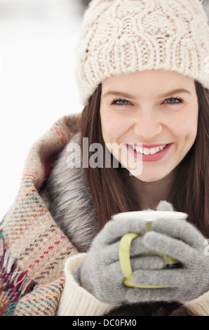 Close up portrait of woman in knit hat and gloves drinking coffee Stock Photo