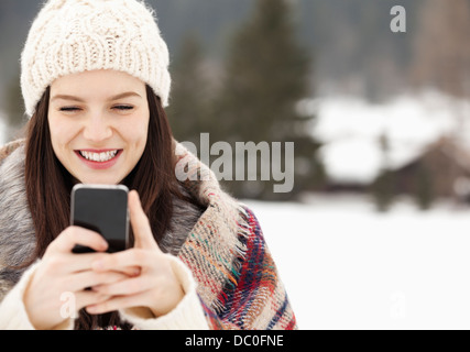 Close up of woman in knit hat text messaging with cell phone Stock Photo