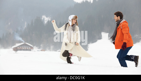 Couple running in snowy field Stock Photo