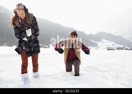 Happy couple walking through deep snow in field Stock Photo