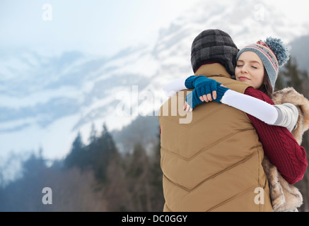 Serene couple hugging with mountains in background Stock Photo