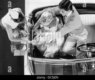 1950s DRIVE-IN RESTAURANT CARHOP WAITRESS ON ROLLER SKATES SERVING COUPLE IN 1955 T-BIRD CAR BURGERS AND MILKSHAKES Stock Photo