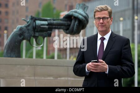 German Foreign Minister Guido Westerwelle stands in front of the sculpture 'Non Violence' also known as 'The Knotted Gun' by Swedish artist Carl Fredrik Reutersward outside of the United Nations (UN) in New York City, New York, USA, 03 June 2013. The scultpure was a gift from Luxembourg to the UN in 1988. Photo: TIM BRAKEMEIER Stock Photo