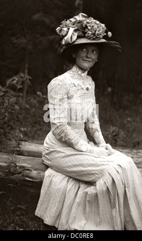 1900s 1910s TURN OF CENTURY BEAUTY ANONYMOUS WOMAN IN WHITE DRESS BIG HAT FLOWERS RIBBONS SUBTLE SMILE MICHIGAN USA Stock Photo