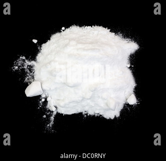 A small pile of white baking soda on a black background. Stock Photo