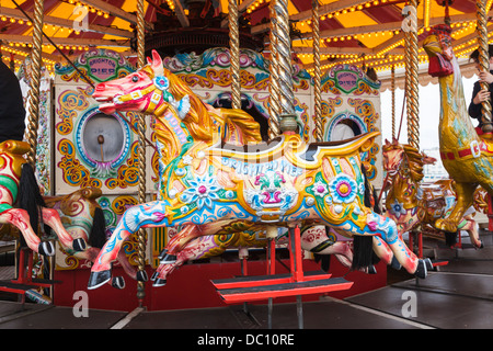 Brightly coloured horse on merry-go-round in the funfair on Brighton Pier (Palace Pier), England Stock Photo