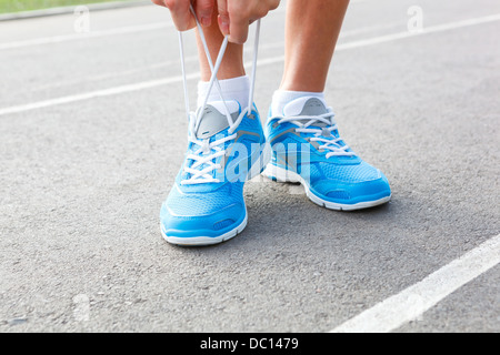 Closeup of Young Woman Tying Sports Shoe - concept image Stock Photo
