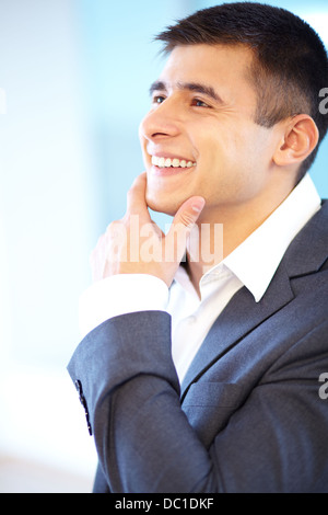Portrait of cheerful businessman touching his chin Stock Photo