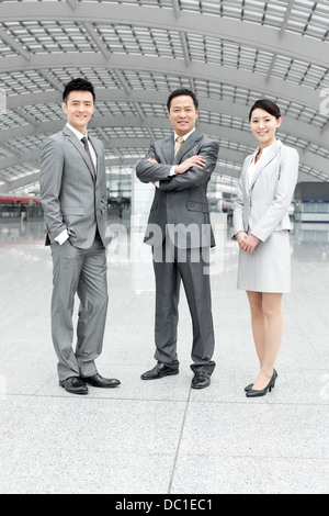 Confident Chinese business people in airport lobby Stock Photo