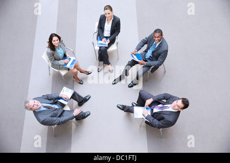 High angle portrait of smiling business people meeting in circle Stock Photo