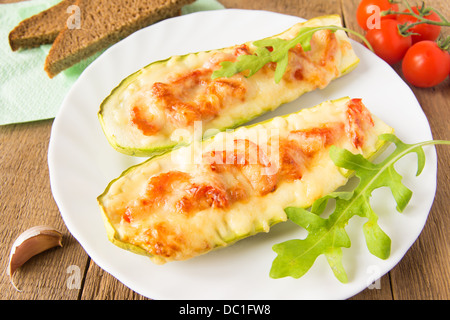 Zucchini cheese stuffed on white plate and wooden background. Stock Photo