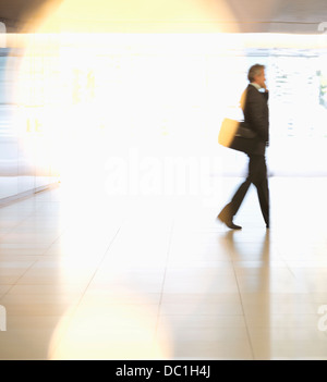 Businessman walking in lobby Stock Photo