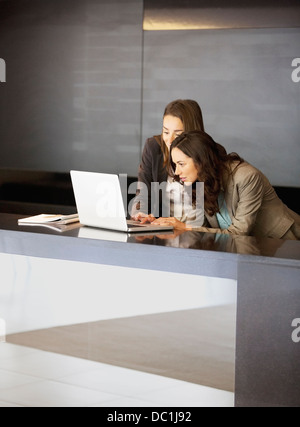 Businesswoman using laptop in lobby Stock Photo