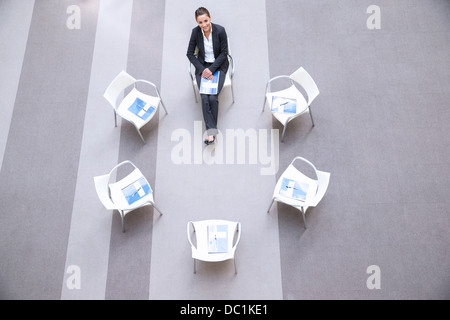 High angle portrait of smiling woman sitting at chair in circle Stock Photo