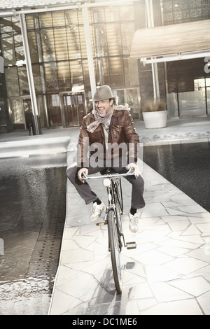 Mid adult man enjoying bike ride in city Stock Photo